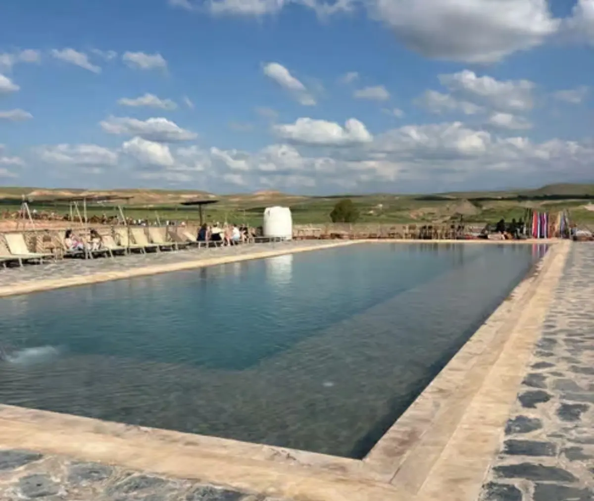 Long pool lined with sun loungers in the Agafay Desert