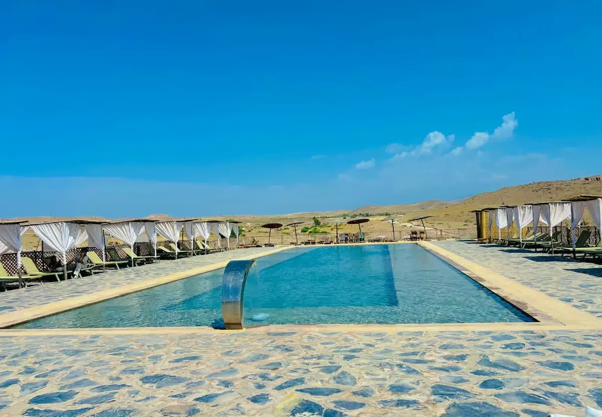 Pool and white tents under a blue sky