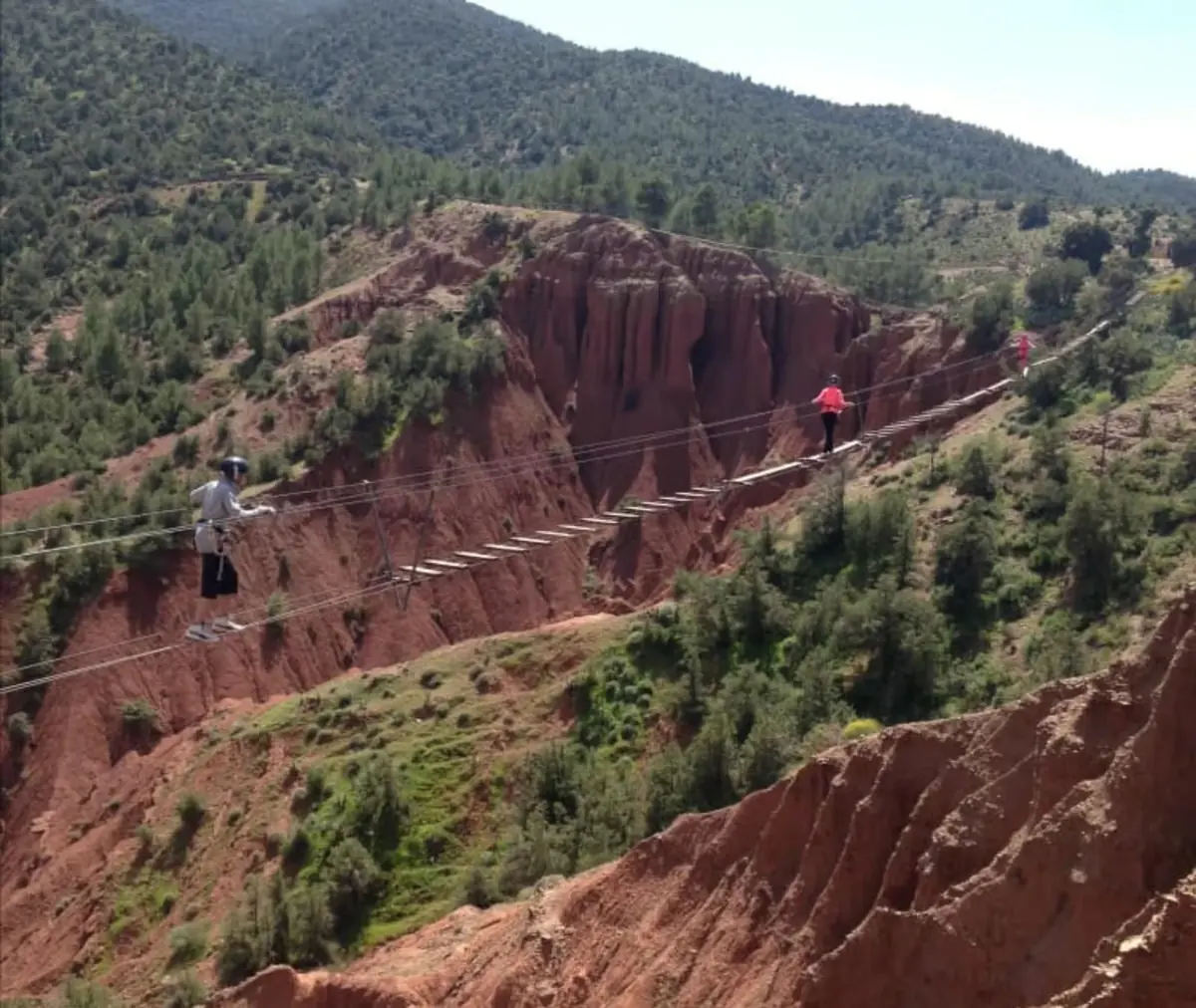 Zipline crossing a red-earth canyon in the Atlas Mountains